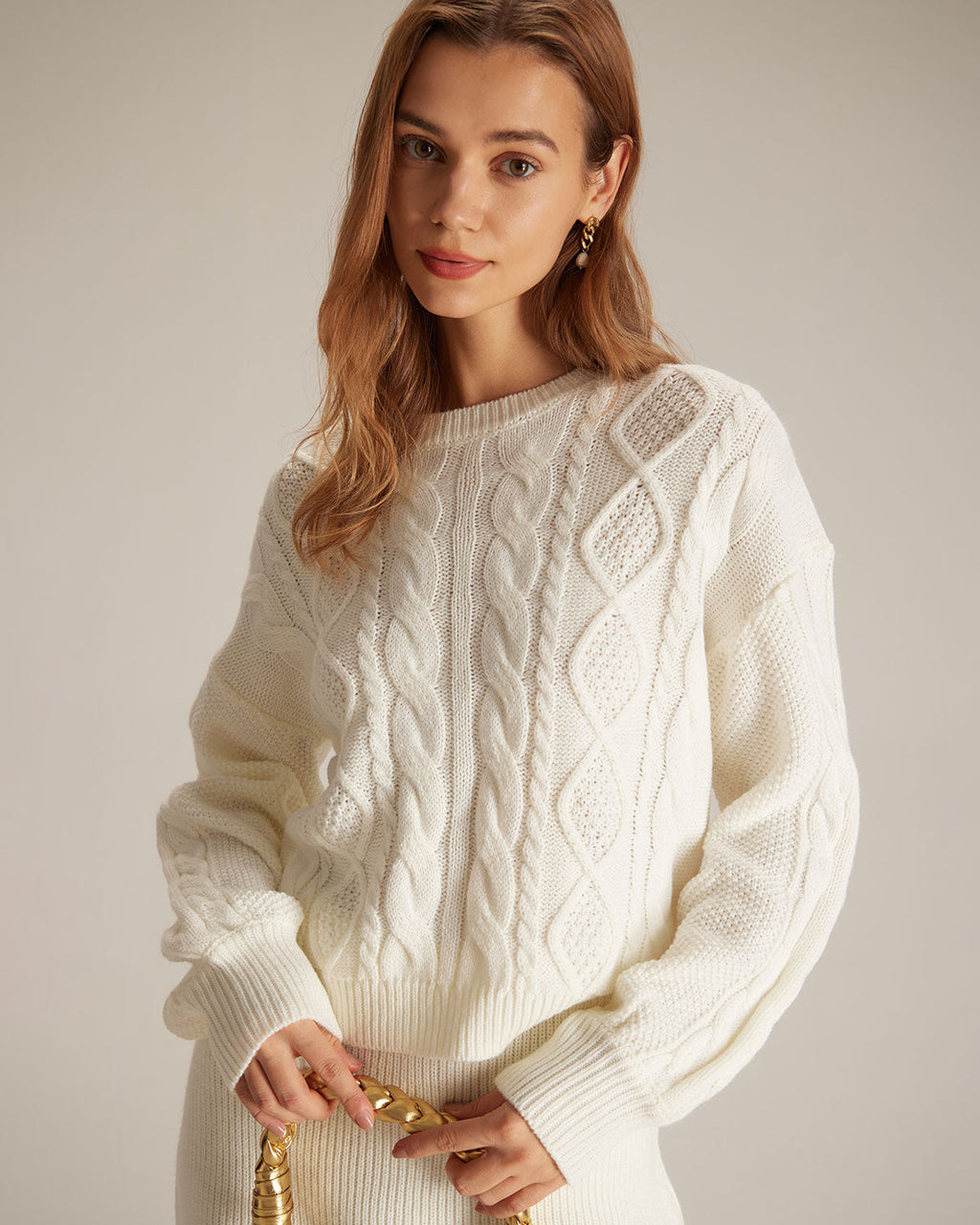 Suéter beige de cuello redondo, tejido trenzado y acanalado