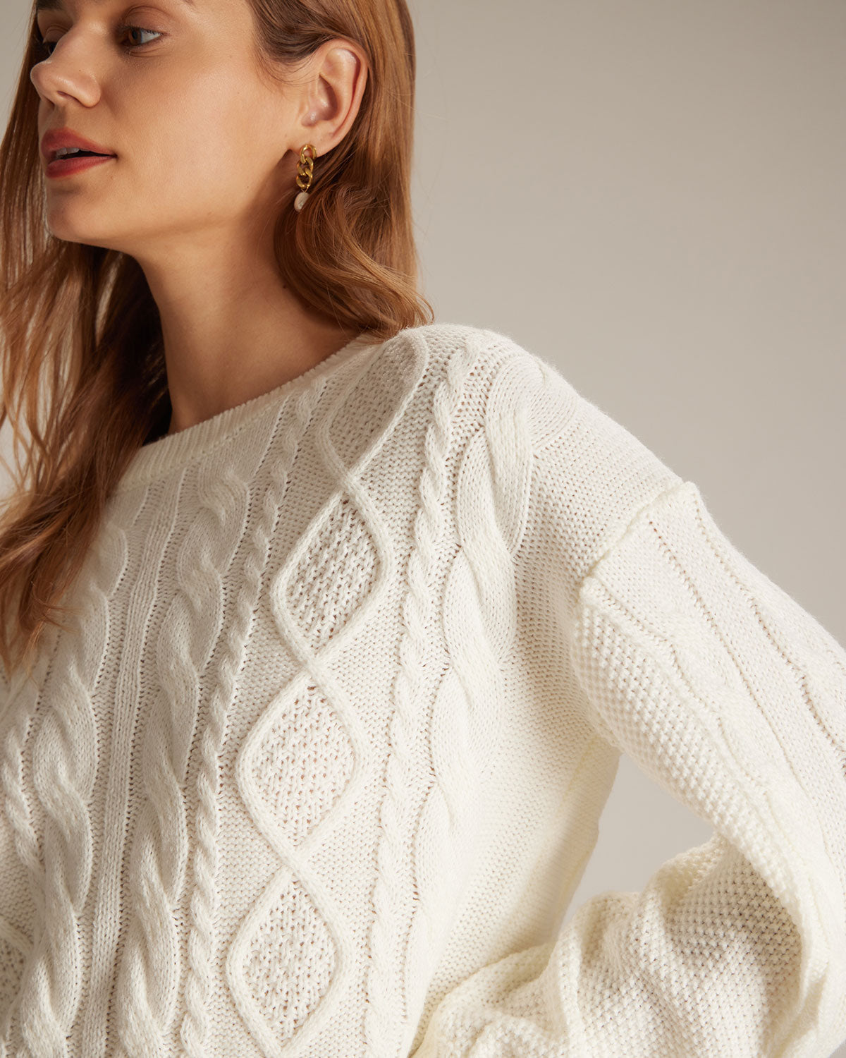 Suéter beige de cuello redondo, tejido trenzado y acanalado