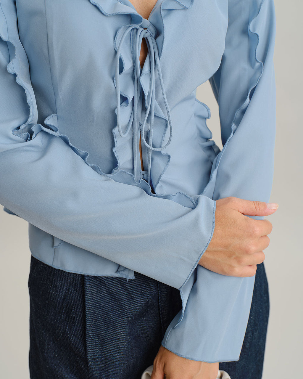 Blusa elegante azul con volantes, escote en V y botones delanteros