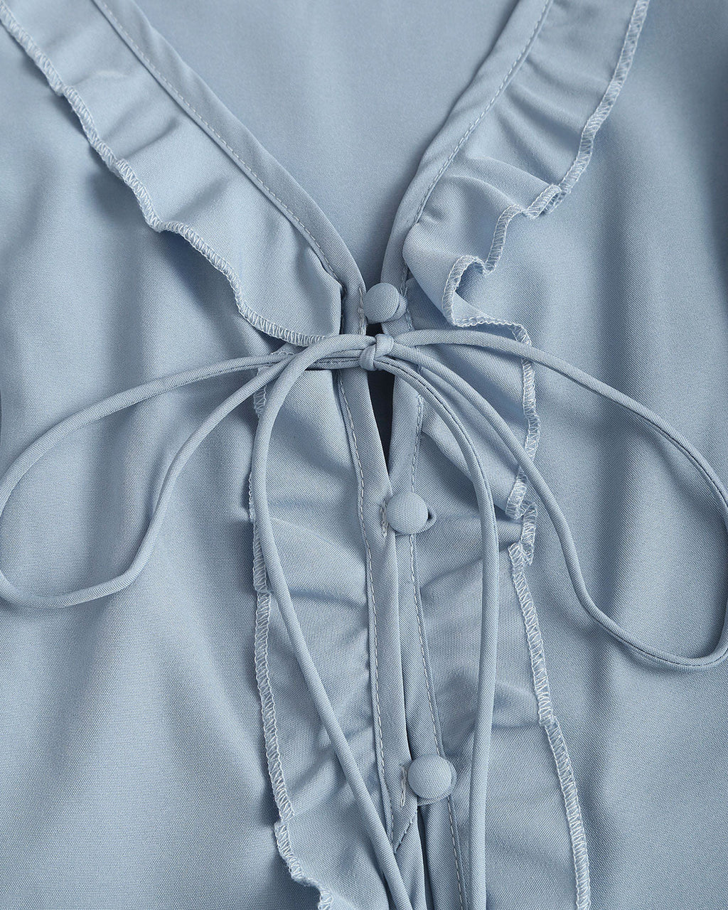 Blusa elegante azul con volantes, escote en V y botones delanteros
