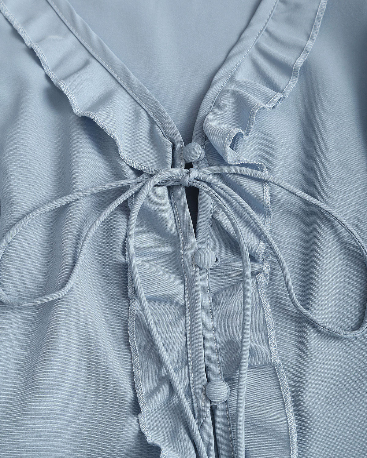 Blusa elegante azul con volantes, escote en V y botones delanteros
